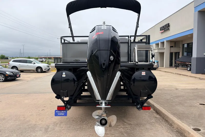 Slide: The Image of 2022 Regency 250 DL3 pontoon boat with powerful outboard motor, parked at dealership. - 7