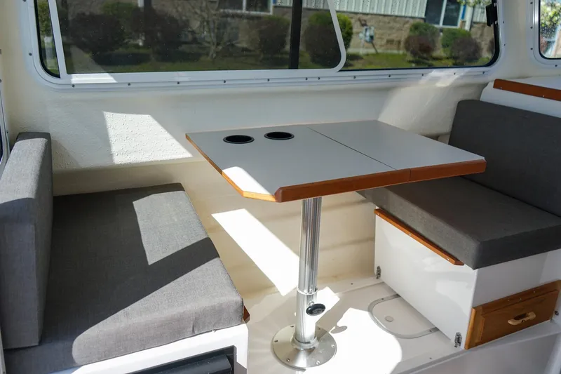 Slide: The Image of Interior of 2024 C-Dory 23' Venture Sport boat with seating and table. - 16