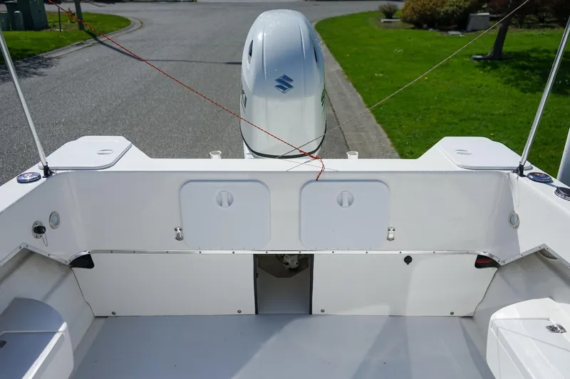 Slide: The Image of 2024 C-Dory 23' Venture Sport boat with outboard motor, docked on a sunny day. - 7