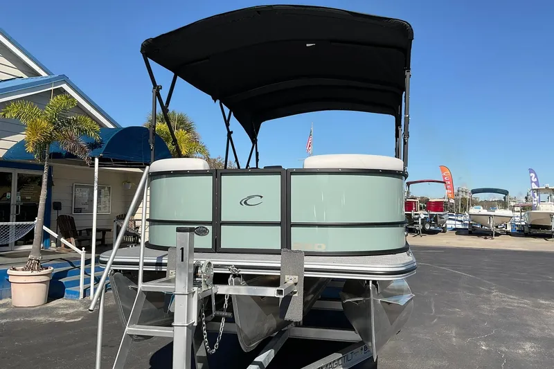Slide: The Image of 2026 Crest Conquest 230 SLSC pontoon boat on display at a marina. - 2
