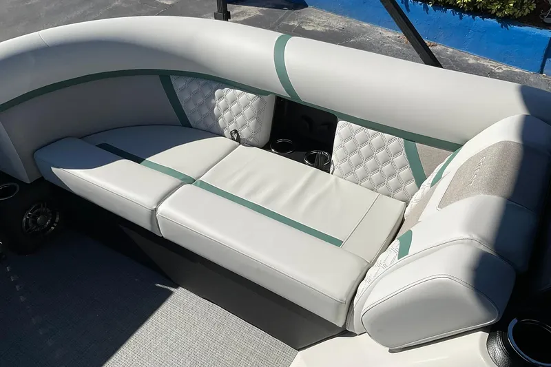 Slide: The Image of 2026 Crest Conquest 230 SLSC boat interior with elegant white and green seating. - 29