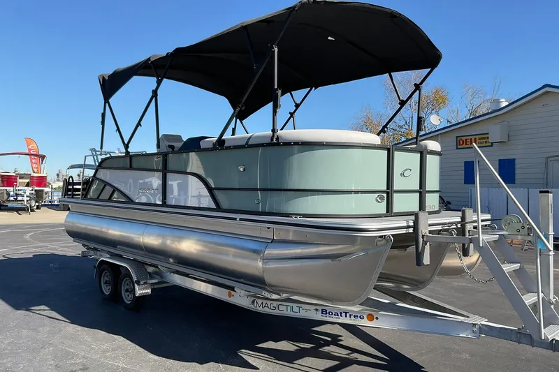 Slide: The Image of 2026 Crest Conquest 230 SLSC pontoon boat on trailer, featuring sleek design and canopy. - 3