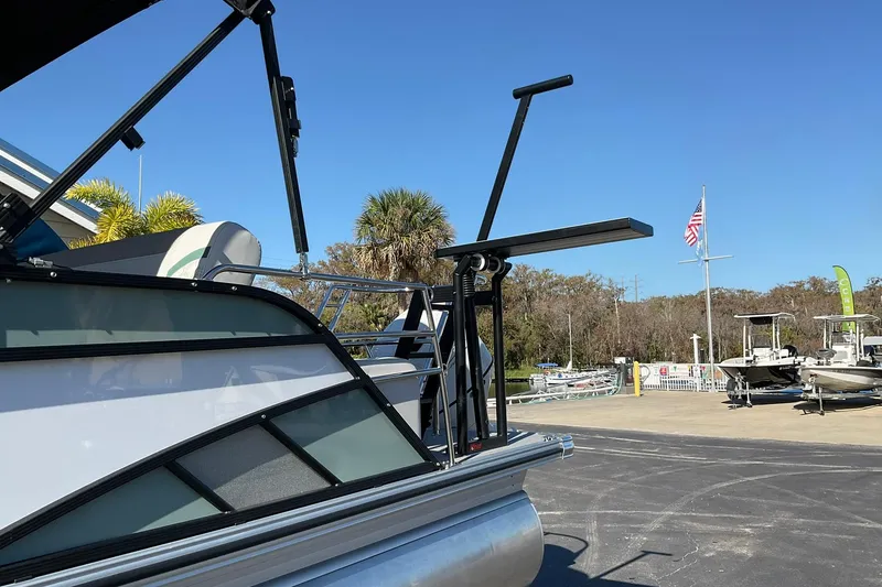 Slide: The Image of 2026 Crest Conquest 230 SLSC pontoon boat at a marina under clear blue sky. - 36