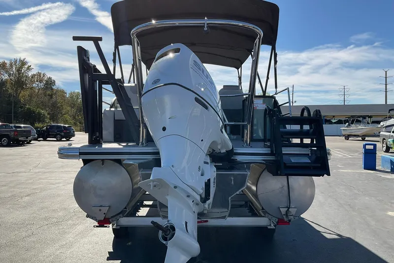 Slide: The Image of 2026 Crest Conquest 230 SLSC pontoon boat with outboard motor, parked outdoors. - 7