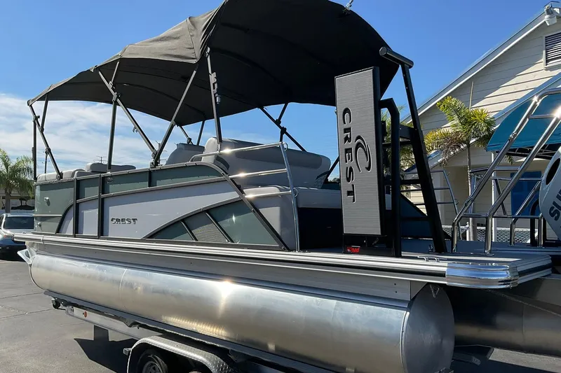 Slide: The Image of 2026 Crest Conquest 230 SLSC pontoon boat with canopy, parked outdoors. - 8