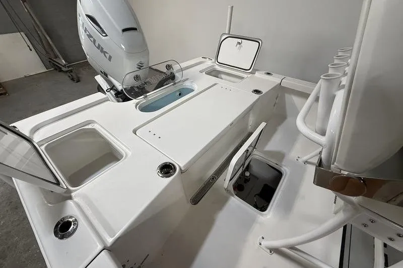 Slide: The Image of 2026 Sea Pro 250 Bay boat interior with Suzuki engine, featuring storage compartments and rod holders. - 10