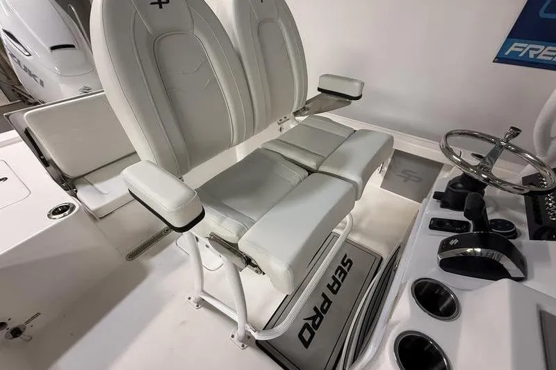 Slide: The Image of 2026 Sea Pro 250 Bay boat interior with dual white captain's chairs and steering console. - 13