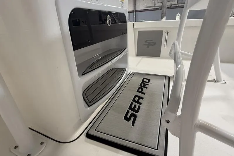 Slide: The Image of 2026 Sea Pro 250 Bay boat interior with branded mat and storage compartments. - 16