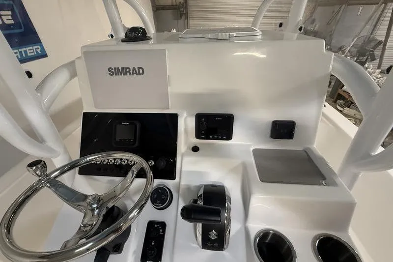 Slide: The Image of 2026 Sea Pro 250 Bay boat console with Simrad electronics and steering wheel. - 17
