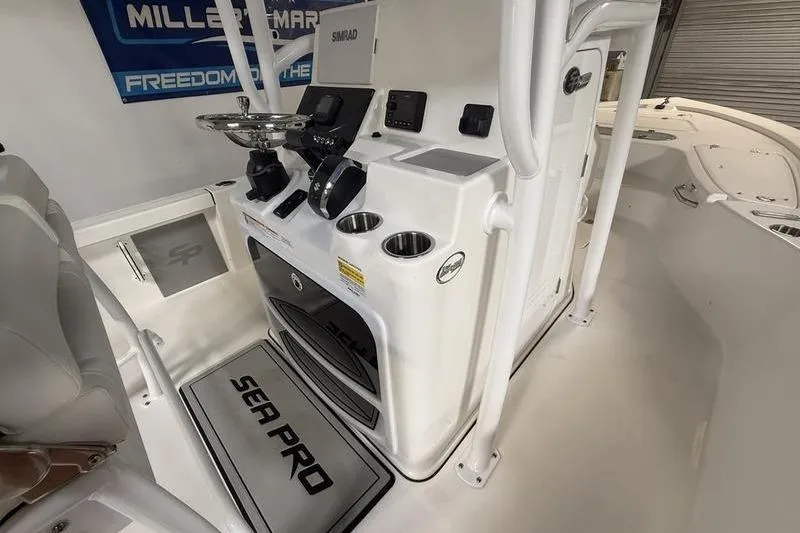 Slide: The Image of 2026 Sea Pro 250 Bay boat interior with steering console and cup holders. - 19