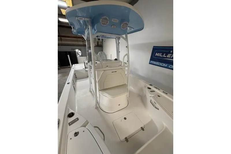 Slide: The Image of 2026 Sea Pro 250 Bay boat interior with seating and console, in a showroom setting. - 24