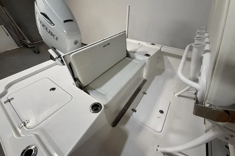 Slide: The Image of 2026 Sea Pro 250 Bay boat interior with Suzuki engine and seating area. - 9