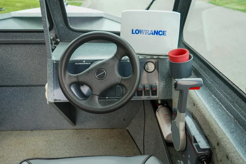 Slide: The Image of 2010 Alumaweld Stryker Sport 20 boat dashboard with steering wheel and Lowrance device. - 14