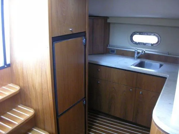 Slide: The Image of Interior of 2009 Tiara Yachts 4300 Sovran with kitchen and wood paneling. - 14