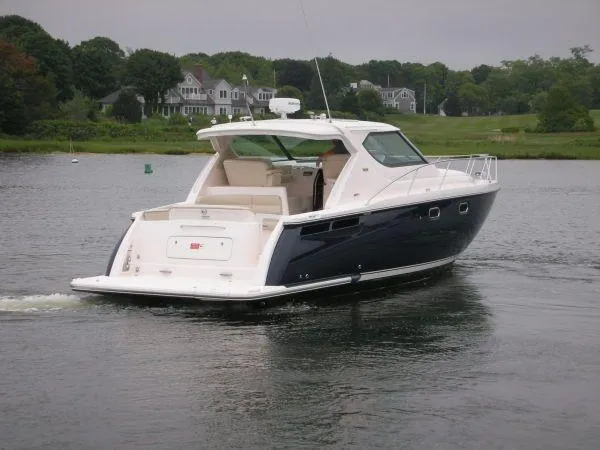Slide: The Image of 2009 Tiara Yachts 4300 Sovran on calm water near coastal homes. - 4