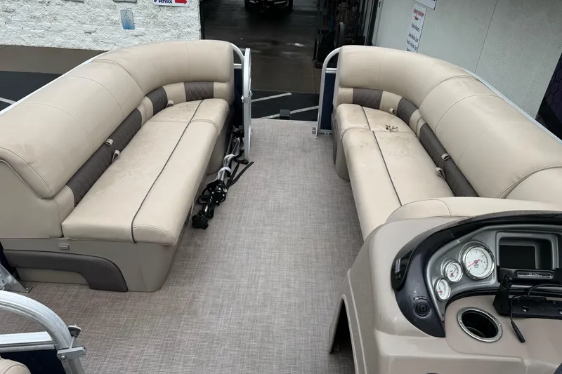 Slide: The Image of 2021 Sun Tracker Party Barge 20 DLX interior with beige seating and control panel. - 15