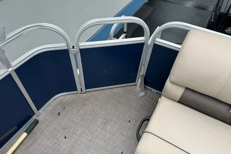 Slide: The Image of 2021 Sun Tracker Party Barge 20 DLX interior with beige seating and blue paneling. - 18