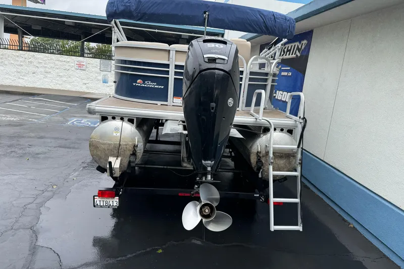 Slide: The Image of 2021 Sun Tracker Party Barge 20 DLX pontoon boat with Mercury outboard motor in parking lot. - 4