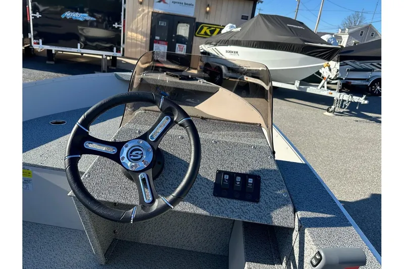 Slide: The Image of 2026 Smoker Craft Angler 16 SC boat interior with steering wheel and dashboard controls. - 10