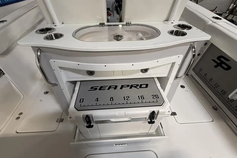 Slide: The Image of 2026 Sea Pro 262 DLX boat interior with fishing station and storage compartments. - 12