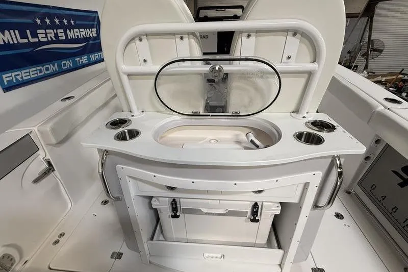 Slide: The Image of 2026 Sea Pro 262 DLX boat interior with fishing station and storage compartments. - 13