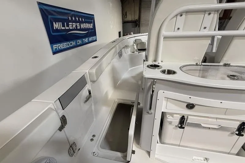 Slide: The Image of 2026 Sea Pro 262 DLX boat interior with storage and seating, displayed at Miller's Marine. - 14