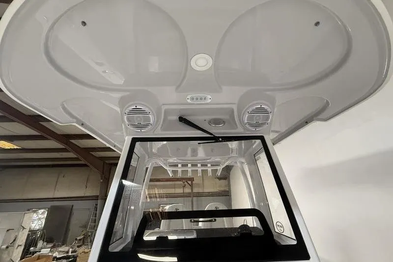 Slide: The Image of 2026 Sea Pro 262 DLX boat interior, featuring speakers and a windshield in a warehouse setting. - 16
