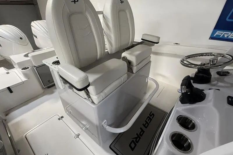 Slide: The Image of 2026 Sea Pro 262 DLX boat interior with white seating and steering console. - 17