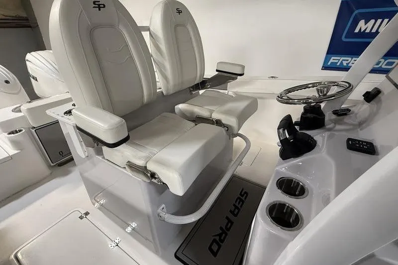 Slide: The Image of 2026 Sea Pro 262 DLX boat interior with dual white captain's chairs and steering console. - 18