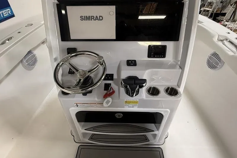 Slide: The Image of 2026 Sea Pro 262 DLX boat console with Simrad display and steering wheel. - 19
