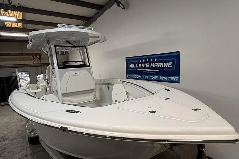 Slide: The Image of 2026 Sea Pro 262 DLX boat displayed indoors at Miller's Marine showroom. - 2