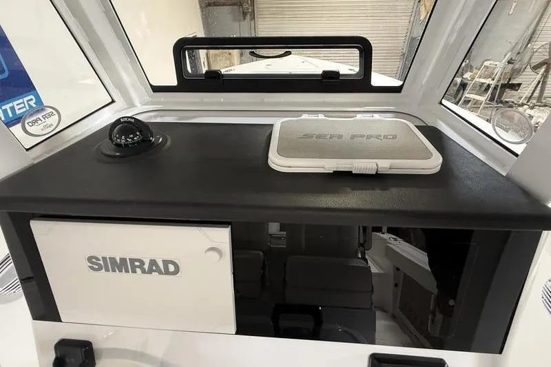 Slide: The Image of 2026 Sea Pro 262 DLX boat dashboard with Simrad equipment and compass. - 20