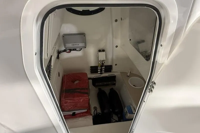 Slide: The Image of Interior storage compartment of 2026 Sea Pro 262 DLX boat, featuring equipment and supplies. - 26
