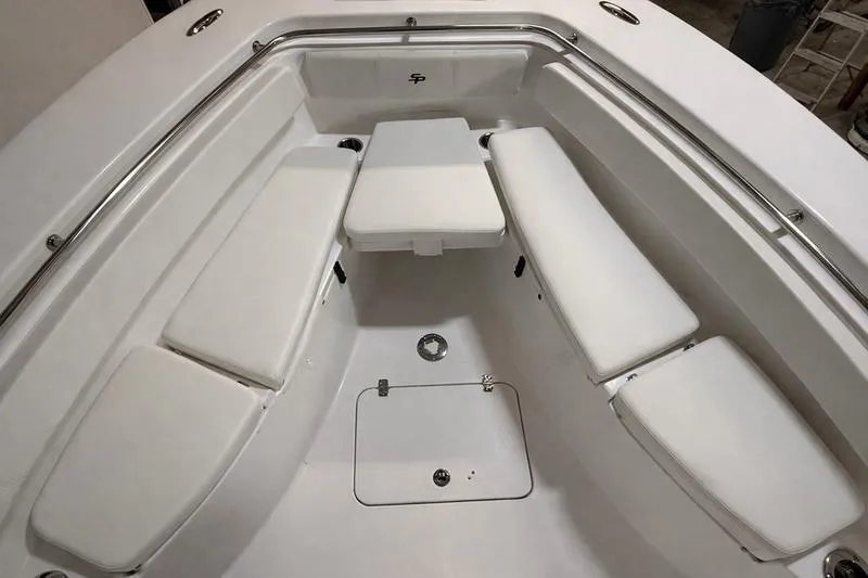 Slide: The Image of 2026 Sea Pro 262 DLX boat interior with white cushioned seating and stainless steel railings. - 32