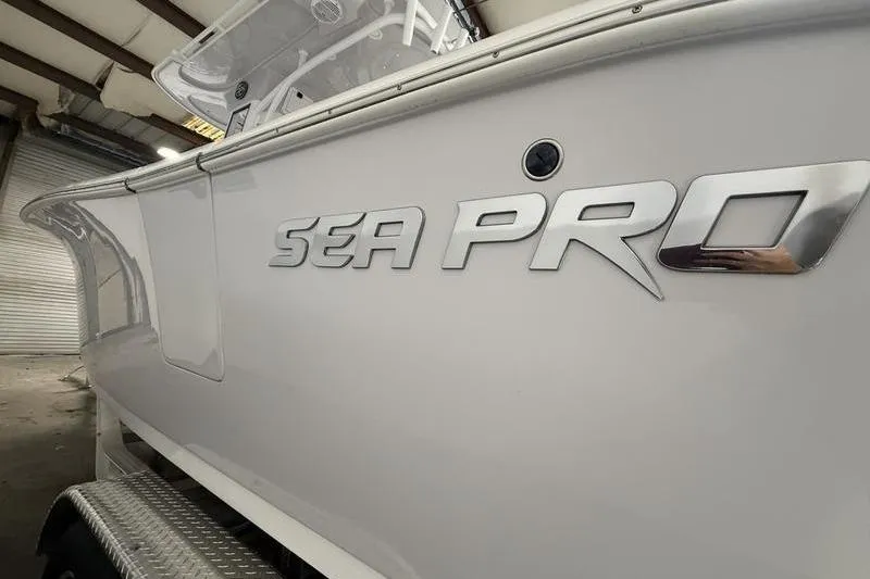 Slide: The Image of 2026 Sea Pro 262 DLX boat side view with logo in a warehouse. - 4