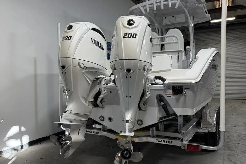 Slide: The Image of 2026 Sea Pro 262 DLX boat with dual Yamaha 200 engines in a garage setting. - 5