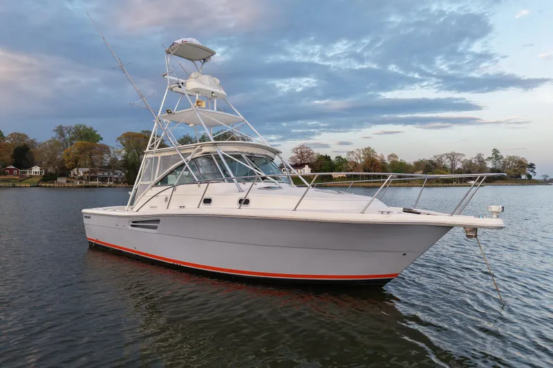 The Image of 2000 Pursuit 3400 Express boat on calm water under a cloudy sky. - 0