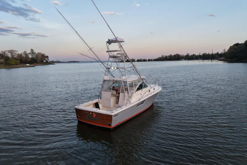 Slide: The Image of 2000 Pursuit 3400 Express boat on calm water at sunset. - 2