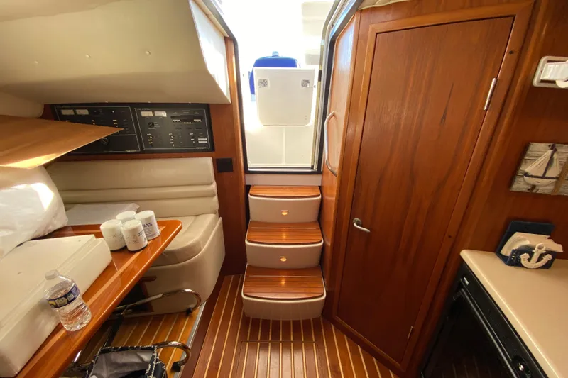 Slide: The Image of Interior of 2000 Pursuit 3400 Express boat with wooden cabinetry and steps. - 20
