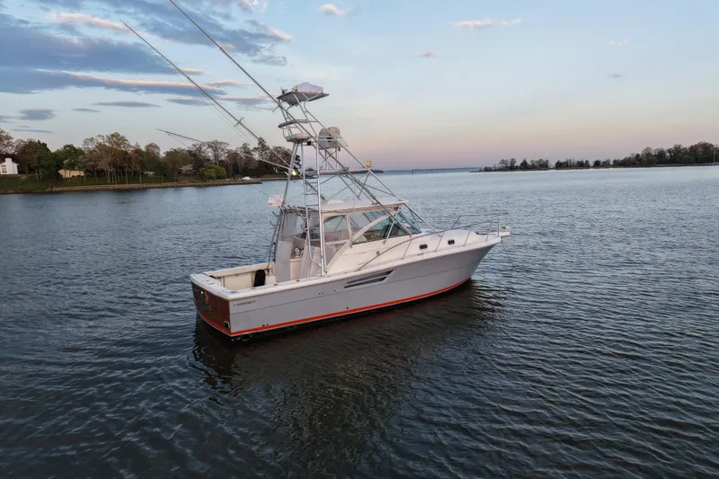 Slide: The Image of 2000 Pursuit 3400 Express boat on calm water at sunset. - 27