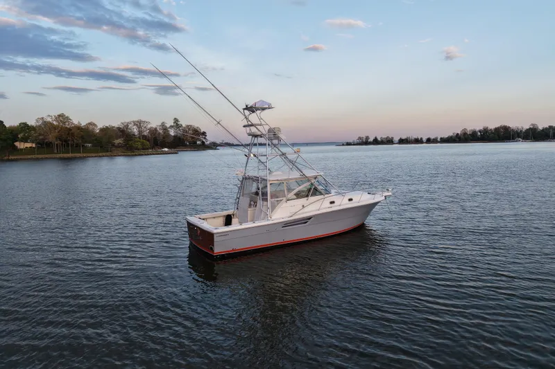 Slide: The Image of 2000 Pursuit 3400 Express boat on calm water at sunset. - 28