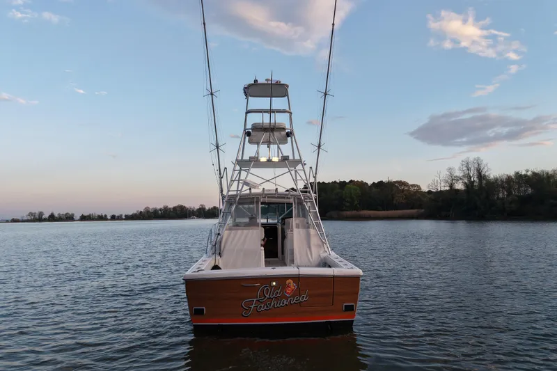 Slide: The Image of 2000 Pursuit 3400 Express boat on calm water at sunset. - 3