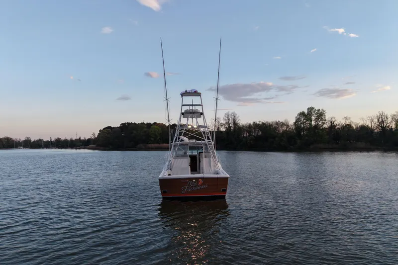 Slide: The Image of 2000 Pursuit 3400 Express boat on calm water at sunset. - 30