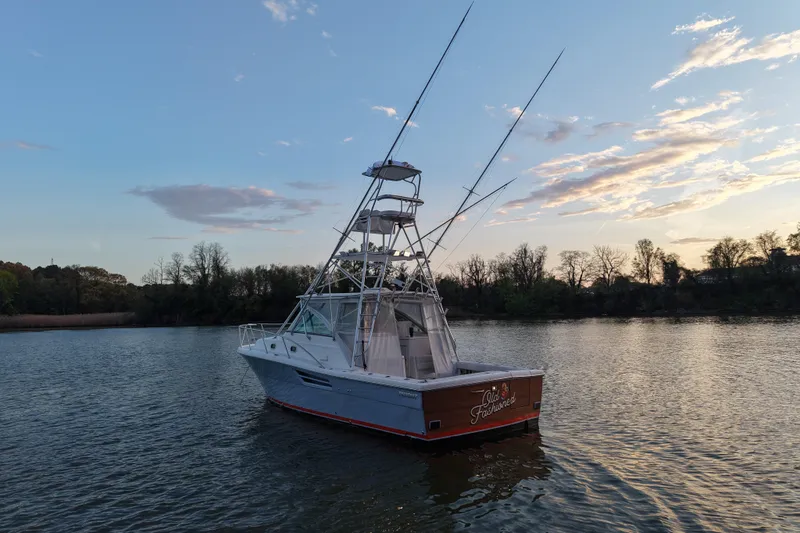 Slide: The Image of 2000 Pursuit 3400 Express boat on calm water at sunset. - 31
