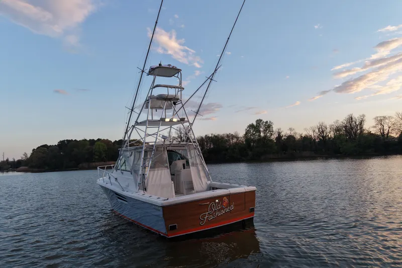Slide: The Image of 2000 Pursuit 3400 Express boat on calm water at sunset. - 4