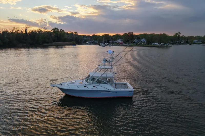 Slide: The Image of 2000 Pursuit 3400 Express boat on calm water at sunset. - 5