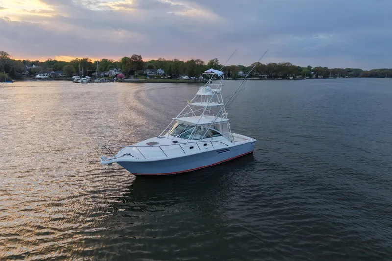 Slide: The Image of 2000 Pursuit 3400 Express boat on calm water at sunset. - 6
