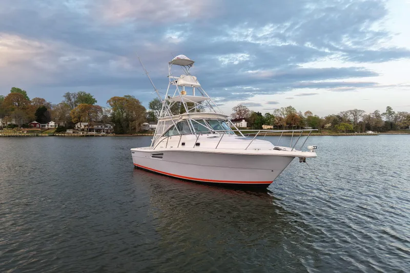 Slide: The Image of 2000 Pursuit 3400 Express boat on calm water with scenic shoreline background. - 9