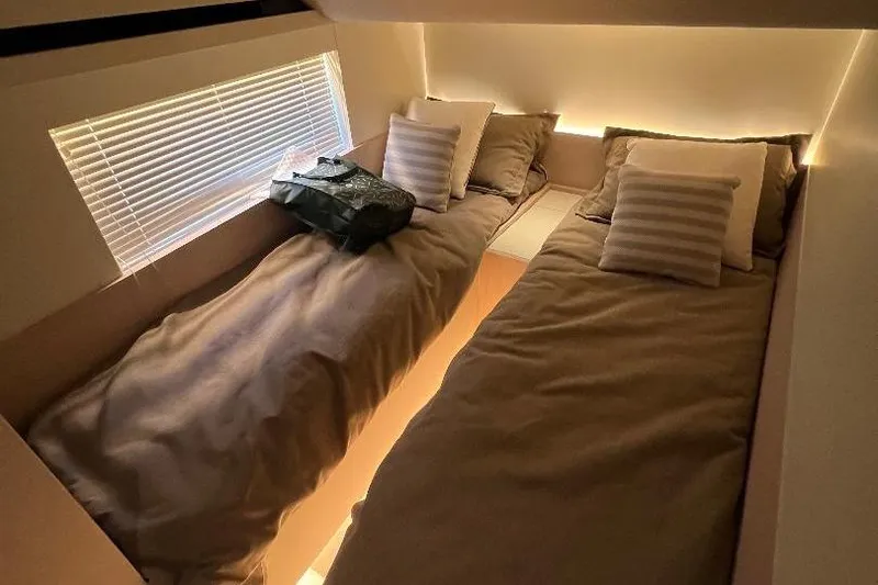 Slide: The Image of Interior of 2025 Azimut SeaDeck6 yacht with twin beds and ambient lighting. - 17