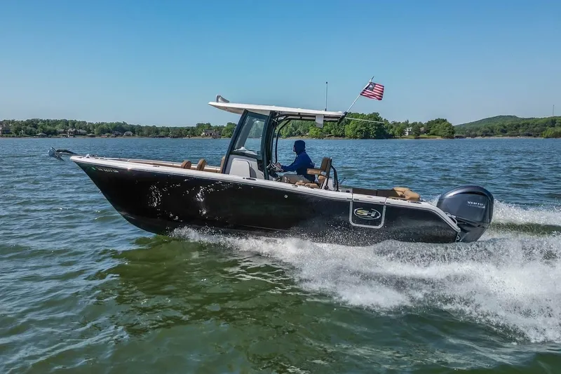 The Image of 2021 Sea Hunt Ultra 255 SE boat cruising on a lake with American flag. - 0